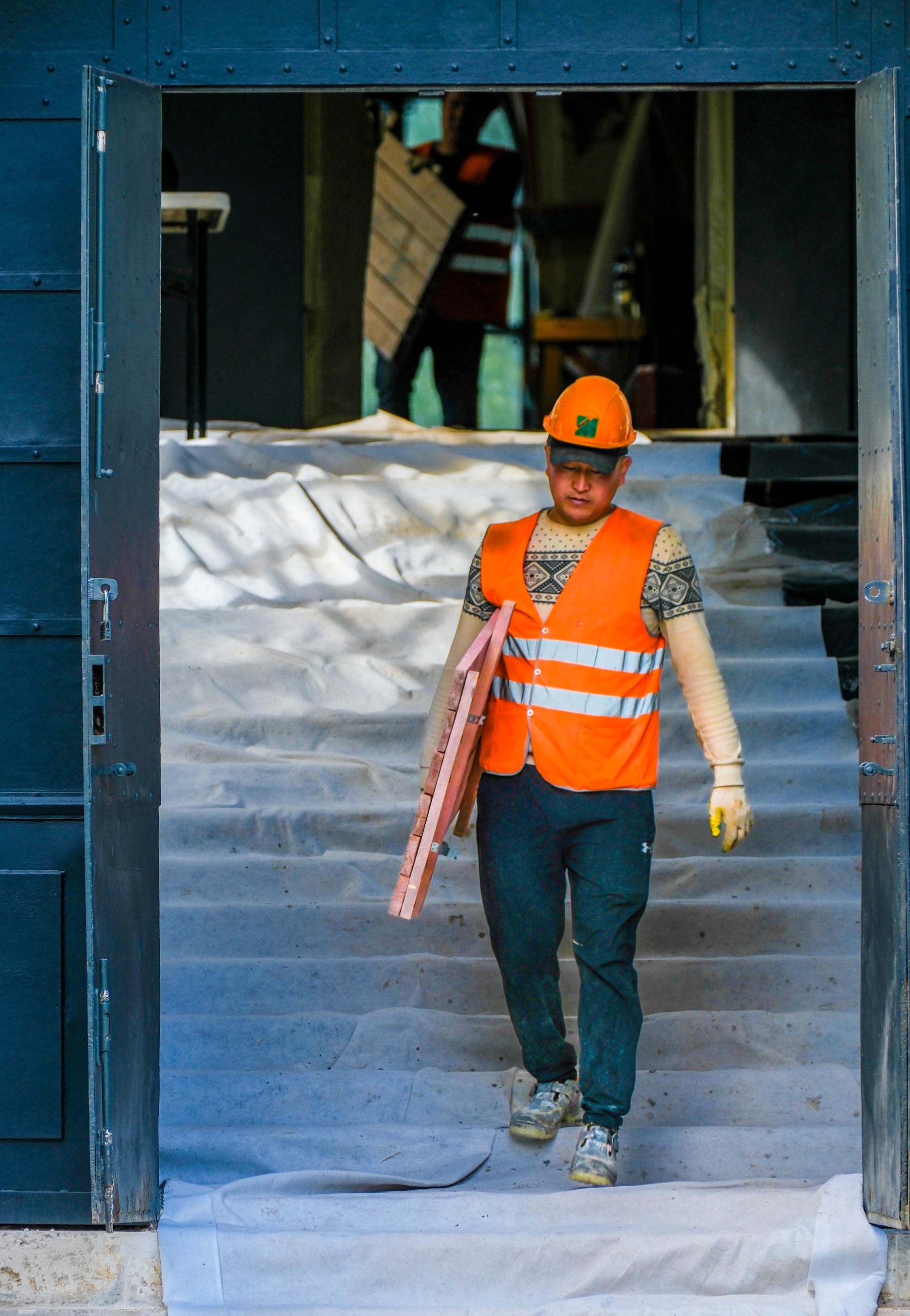 Construction worker carrying tools at a building site